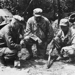 Discussing operations at the 32D Division command post at Aitape, New Guinea, are (from left to right): Maj. Gen. C. P. Hall, commander of task forces; Maj. Gen. William H. Gill, commander of 32D Division; and Maj. Gen. Leonard F. Wing, commander of 43D Division. This photo was probably taken ca. 22 Jul. 1944, about the day the 43D Div. began operating in the Aitape area.